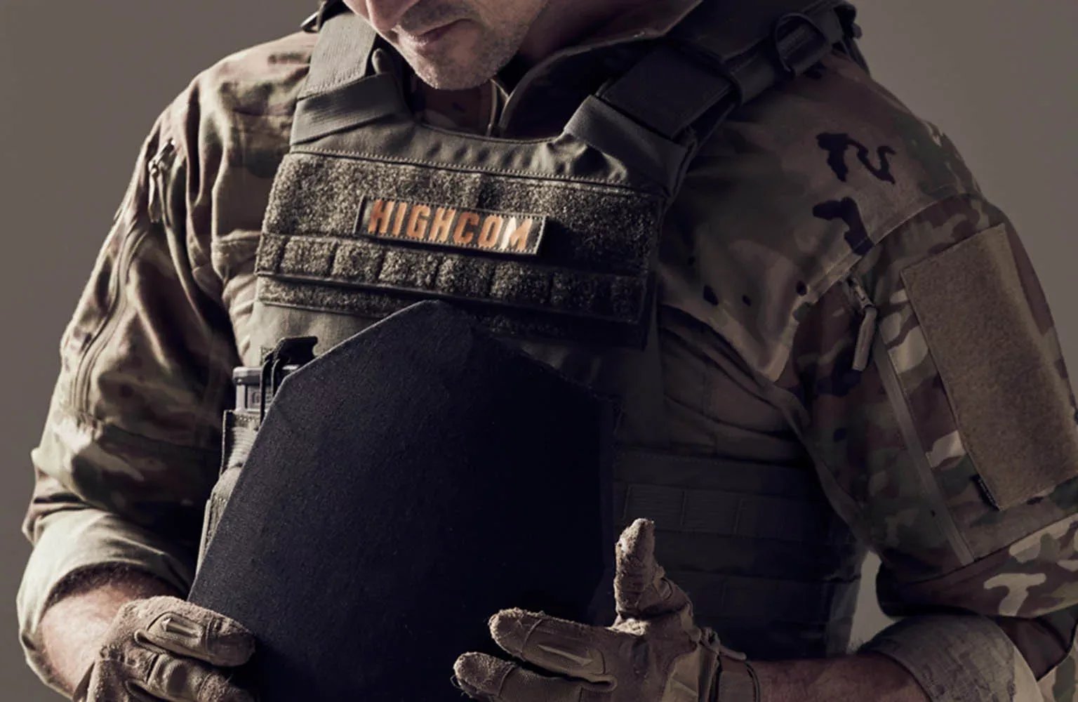 Operator seating a ballistic plate into a HIGHCOM plate carrier