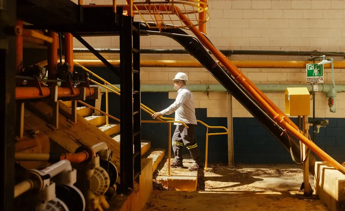 An operator on a gangway above a mill floor
