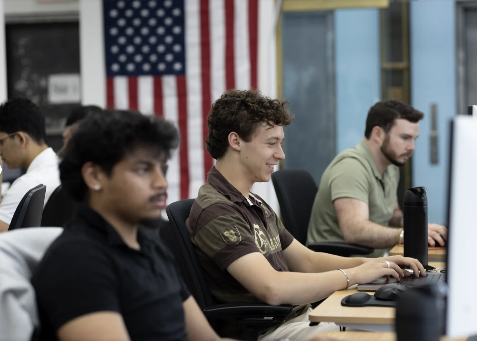 The team at their desks beneath the US flag in the ProDex office