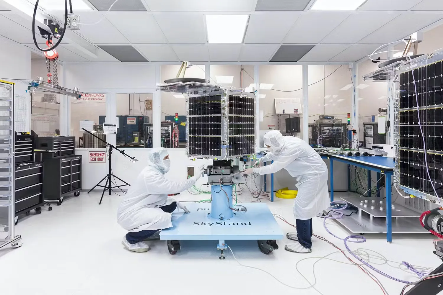 Engineers integrating a satellite in a cleanroom