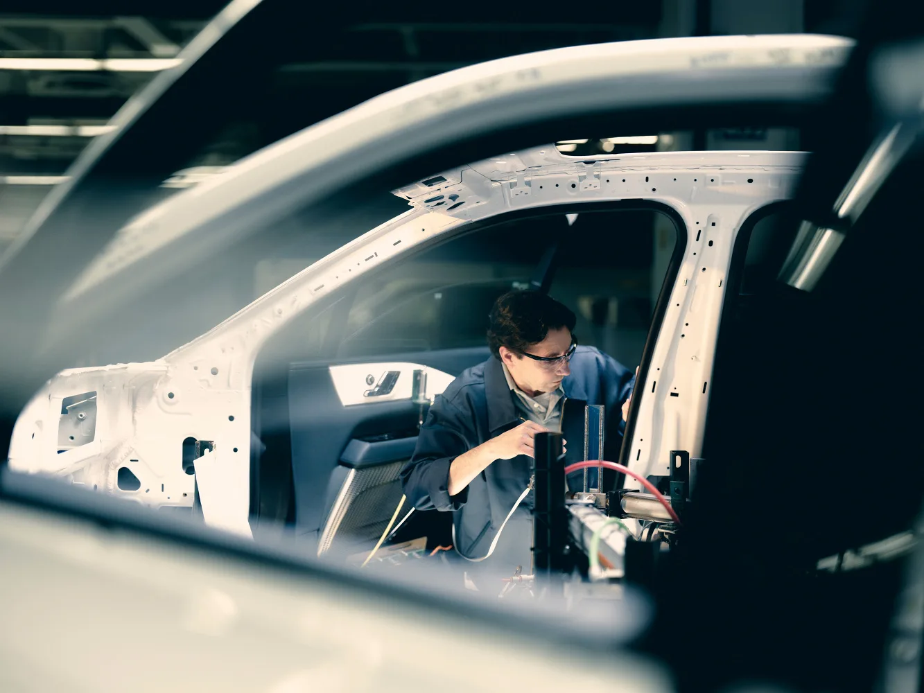 An operator working inside a vehicle body on the line