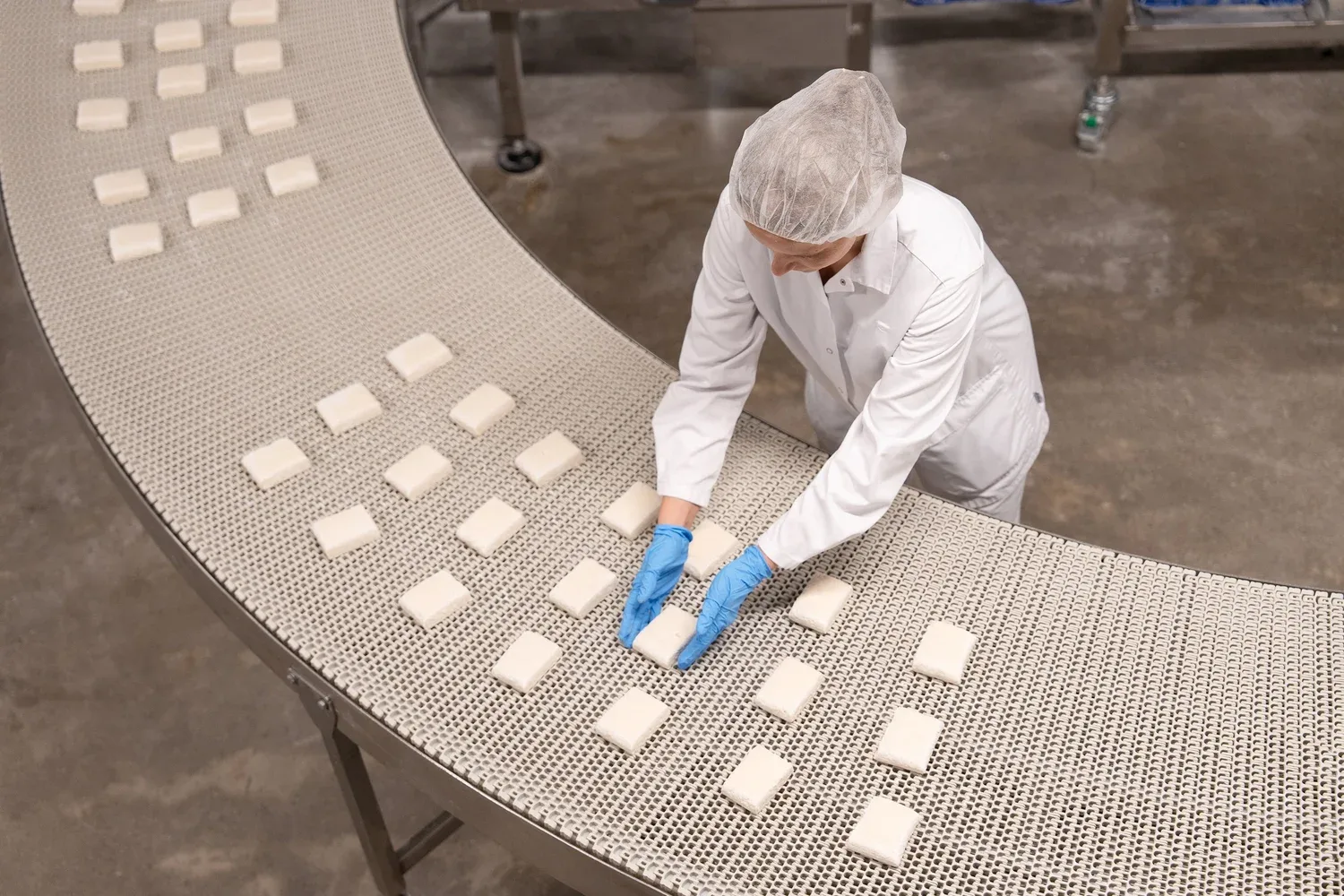 A technician setting product on a packaging conveyor