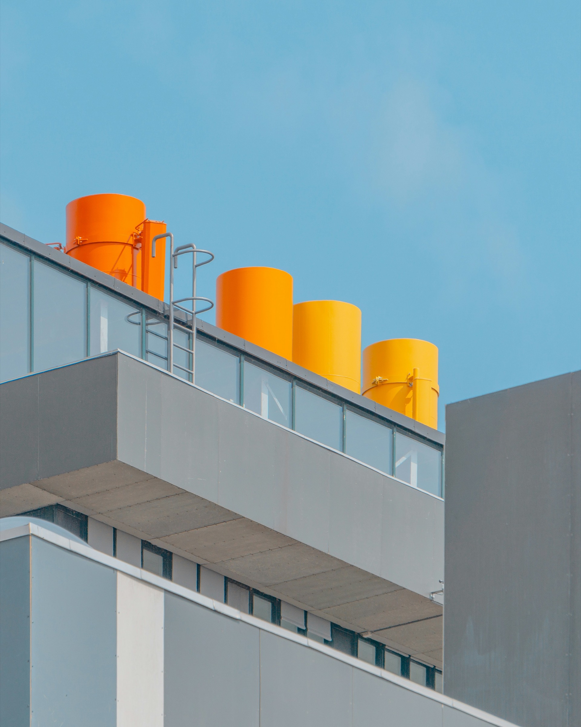 Orange rooftop cylinders on a gray building