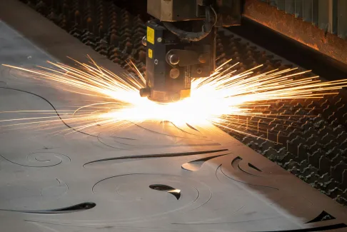 Sparks thrown from a plasma cutting head on a steel sheet